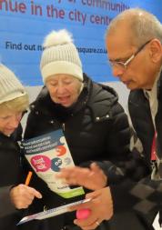 A member of Healthwatch providing an information leaflet to a member of the public in Eldon Square